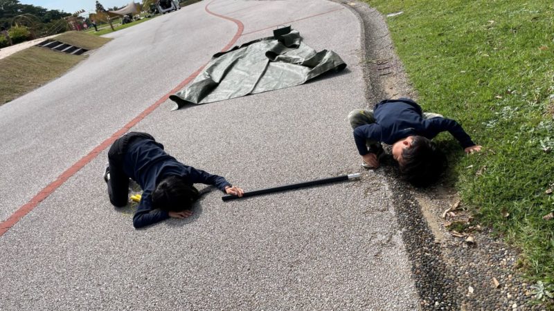 ポールの中を進むダンゴムシを観察する子どもたち