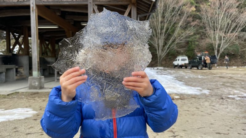 水たまりに張った氷で遊ぶ息子