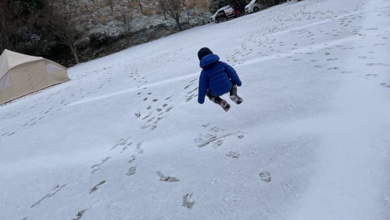 雪の上でジャンプする子ども