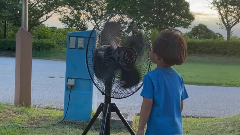 工場扇の前で風を浴びる息子