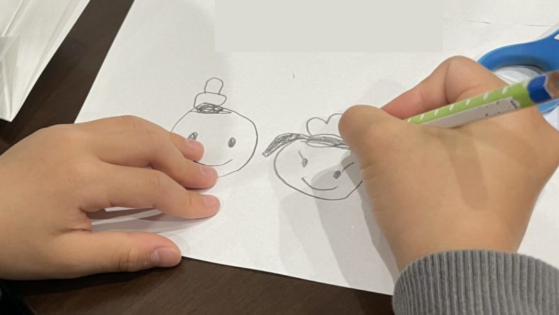 雛人形の顔を描く息子