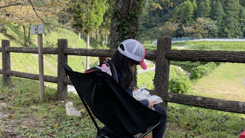 キャンプ場で読書する娘