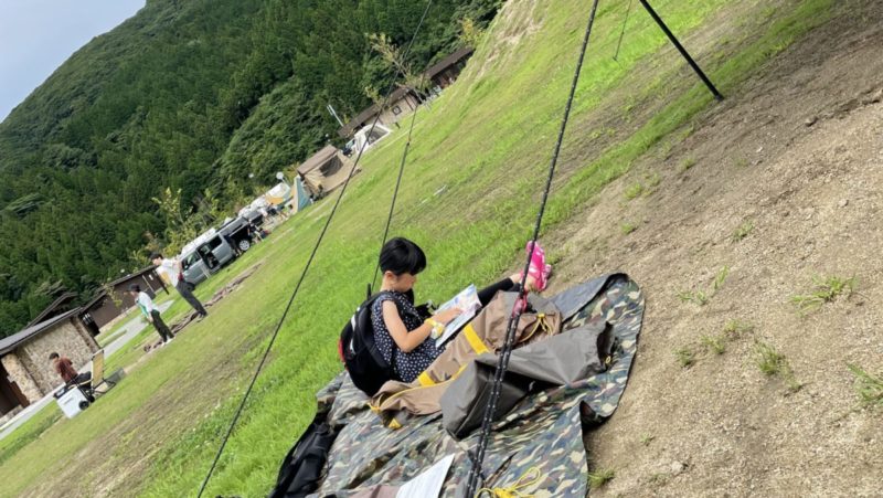 撤収を待ちながら漫画を読む娘